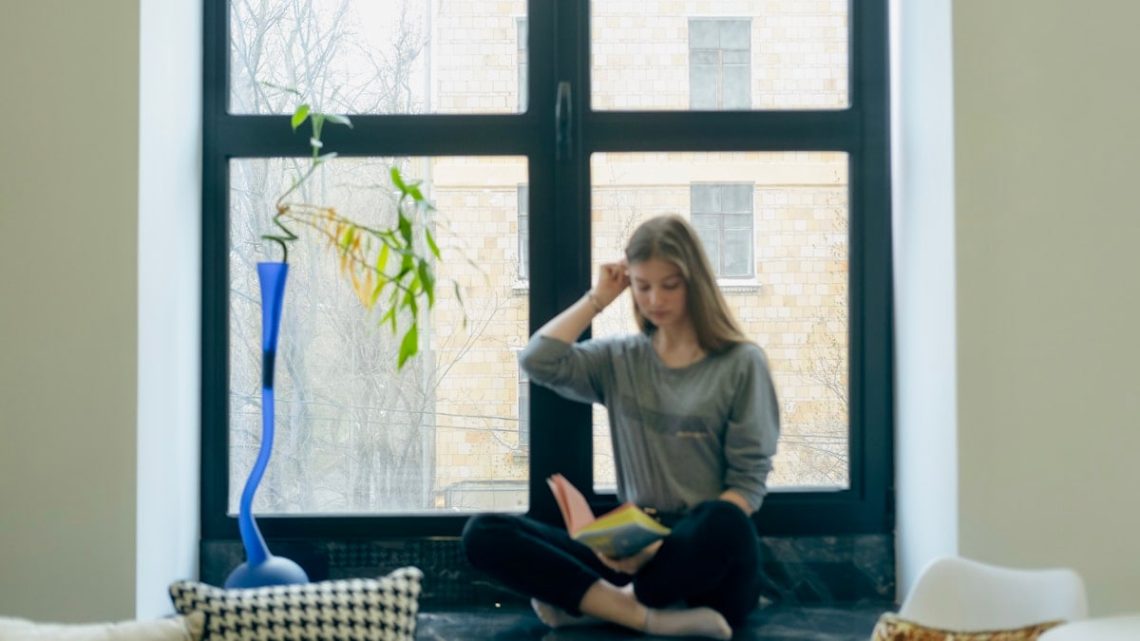 a person sitting next to a window
